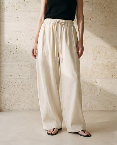 Cream wide-fit pants on model, full-length front view – Moriel Heritage