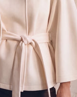The Lorenne cape coat in white — close-up of the tie belt at the waist