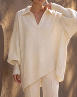 The Lorna Collared Knit in ivory — model with hand to collar showing the open batwing sleeve