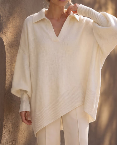 The Lorna Collared Knit in ivory — model with hand to collar showing the open batwing sleeve