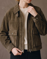 Juniper Suede Utility Jacket in olive worn over a cream knit, half zipped with hand at the collar