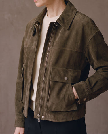 Three-quarter view of the Juniper Suede Utility Jacket with hand in the side pocket