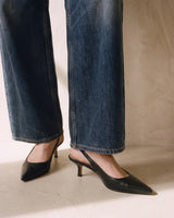 Close-up of the Delphine Wide Leg Jeans hems falling over black slingback heels