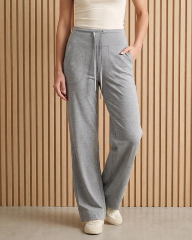 The Rae relaxed pant in light gray — front view with hand in pocket on model