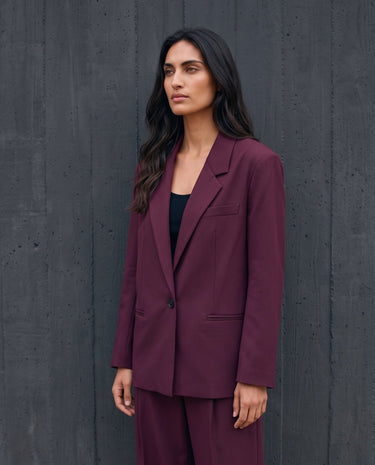 The Aliya Burgundy Blazer Set in burgundy — blazer and trousers, front view on model