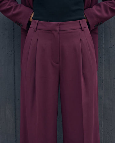 The Aliya Burgundy Blazer Set in burgundy — close-up of the trouser waistband and front pleats