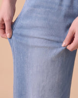 Hands stretching the soft knit denim of the Isla jeans