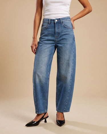 Barrel Jeans in blue — mid-rise barrel-leg denim styled with a white tank, hand in pocket, front view on model