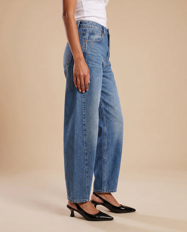 Barrel Jeans in blue — side profile on model showing the rounded barrel leg and tapered hem