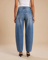 Barrel Jeans in blue — back view on model showing the patch pockets and curved leg