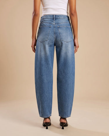 Barrel Jeans in blue — back view on model showing the patch pockets and curved leg