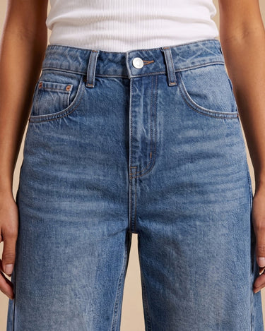 Barrel Jeans in blue — close-up of the mid-rise waistband, button fly and front pockets