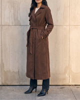 Model with hands in pockets wearing the brown Bexley Trench Coat, three-quarter front view