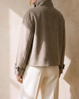 Back view of the Ottilie Funnel Jacket in taupe with standing funnel collar and boxy cropped hem