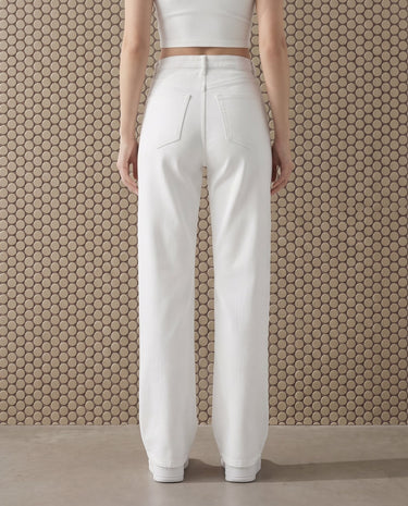 Back view of the white Cali Jean showing the two patch back pockets and the straight wide-leg drape with a turned-up hem