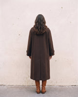 The Chocolate Maxi Coat in chocolate brown — longline coat, back view on model