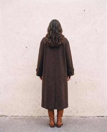 The Chocolate Maxi Coat in chocolate brown — longline coat, back view on model