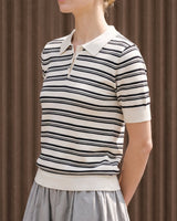 Cosetta Polo in white — front view on model, styled with a grey skirt