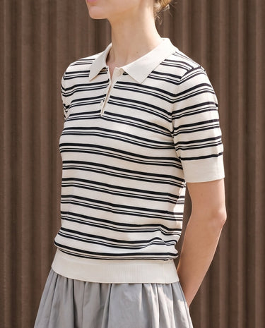 Cosetta Polo in white — front view on model, styled with a grey skirt