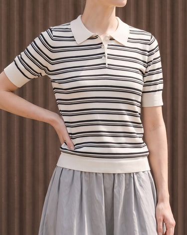 Cosetta Polo in white — three-quarter front view showing the ribbed hem and short sleeves