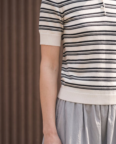 Cosetta Polo in white — cropped front view showing the navy stripes and ribbed hem