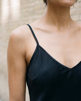 Close-up of the black Eclipse Satin Dress showing the fine shoulder strap, V neckline and satin sheen