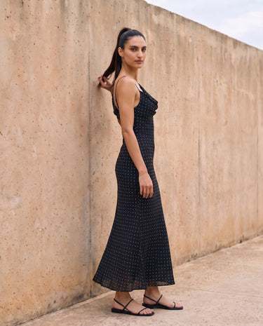 The Elowen Polka Dot Dress in black polka dot — slip maxi dress, side view on model
