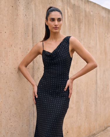The Elowen Polka Dot Dress in black polka dot — slip maxi dress, front view with hand on hip on model