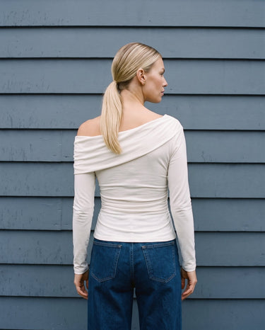 Back view of the white asymmetric shoulder top showing the fitted body – Moriel Heritage
