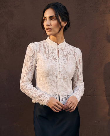 Florence Blouse in white — three-quarter front view on model against a warm backdrop