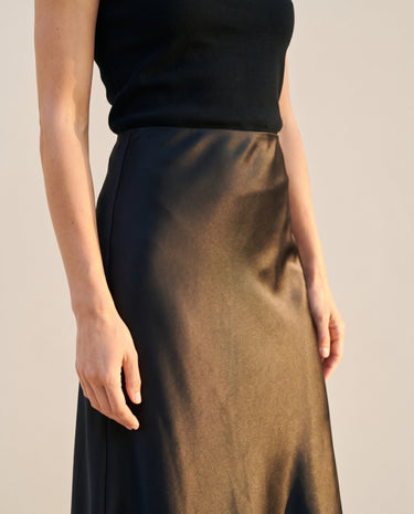 Close-up of black satin midi skirt showing the sheen and waistband – Moriel Heritage