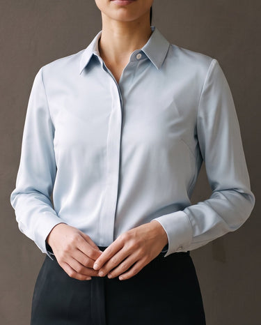 Model wearing the light blue satin-look shirt tucked into black trousers, close front view