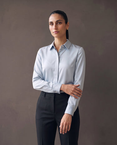 Model in the light blue satin-look office shirt with black tailored trousers, front view