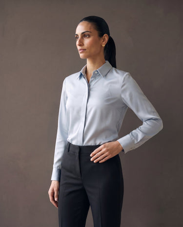Full-length view of the light blue satin-look office shirt styled with black trousers