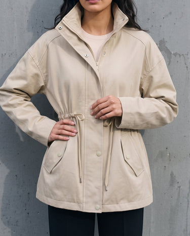 Model wearing the light khaki Halden Coat open, three-quarter front view