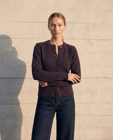 The Frankie Knit Cardi in aubergine — front view on model with indigo wide-leg jeans