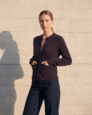 The Frankie Knit Cardi in aubergine — angled view on model, hands in the patch pockets