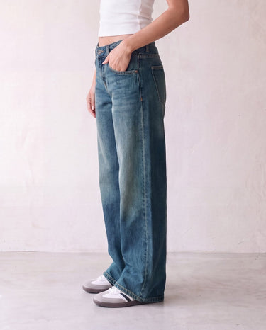 Harlow Low Rise Jeans in washed blue — side profile on model with hand in pocket