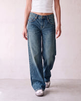 Harlow Low Rise Jeans in washed blue — baggy straight-leg denim in motion, walking view on model