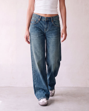 Harlow Low Rise Jeans in washed blue — baggy straight-leg denim in motion, walking view on model
