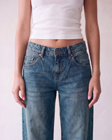 Harlow Low Rise Jeans in washed blue — close-up of the low-rise waistband, button fly and rivets