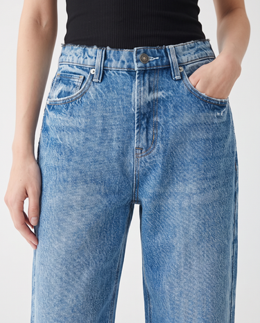 Close-up of Hallie Jeans worn with a black rib tank, showing the vintage blue wash, button and front pockets