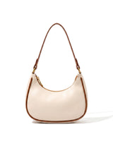 The Ines Crescent Bag in cream with tan trim, front view on a pure white studio background