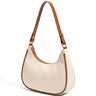 The Ines Crescent Bag in cream with tan trim, studio hero view showing the half-moon silhouette and shoulder strap
