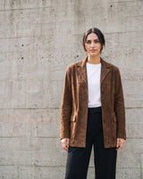 Full-length front view of the dark brown Isla Faux Suede Jacket styled with a white tee and black trousers
