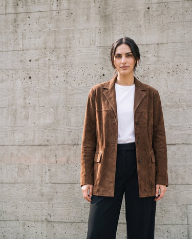 Full-length front view of the dark brown Isla Faux Suede Jacket styled with a white tee and black trousers