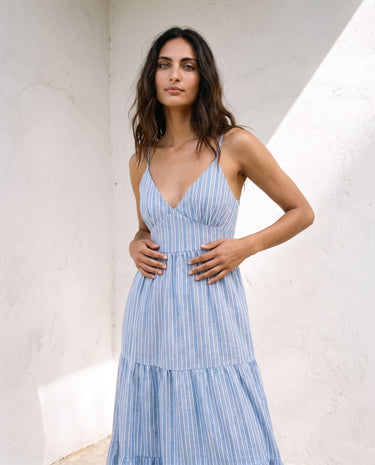 Isla Striped Summer Maxi Dress in blue stripe — V-neck tiered maxi dress, front styling view on model