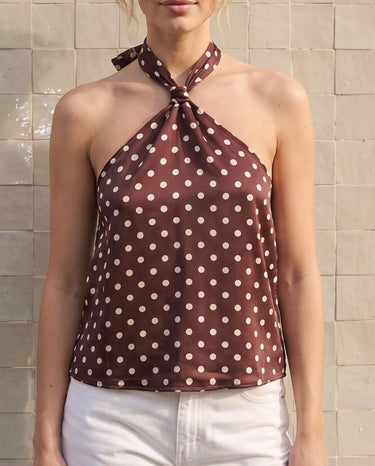 Isola Halter Neck in brown polka dot — front view on model, styled with white jeans