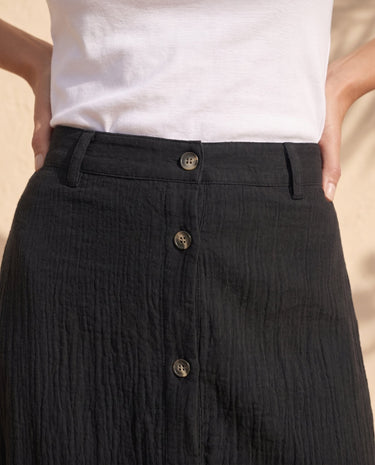 Kyra Flow A Line Skirt in black — close-up of belt loops and button-front detail