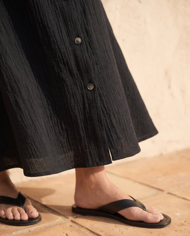 Kyra Flow A Line Skirt in black — close-up of textured hem and lower button detail